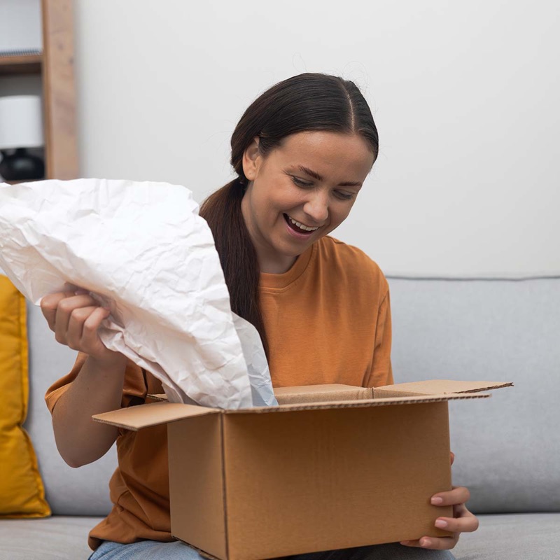 A shopper happily unboxing an online order at home